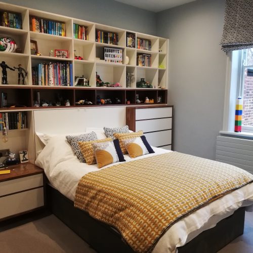 Bed surrounded by shelves and drawers
