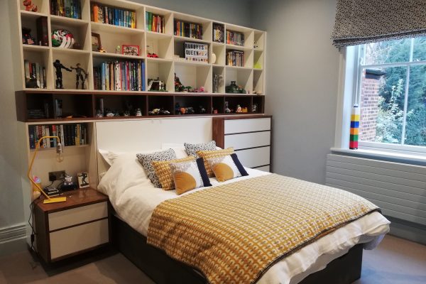 Bed surrounded by shelves and drawers